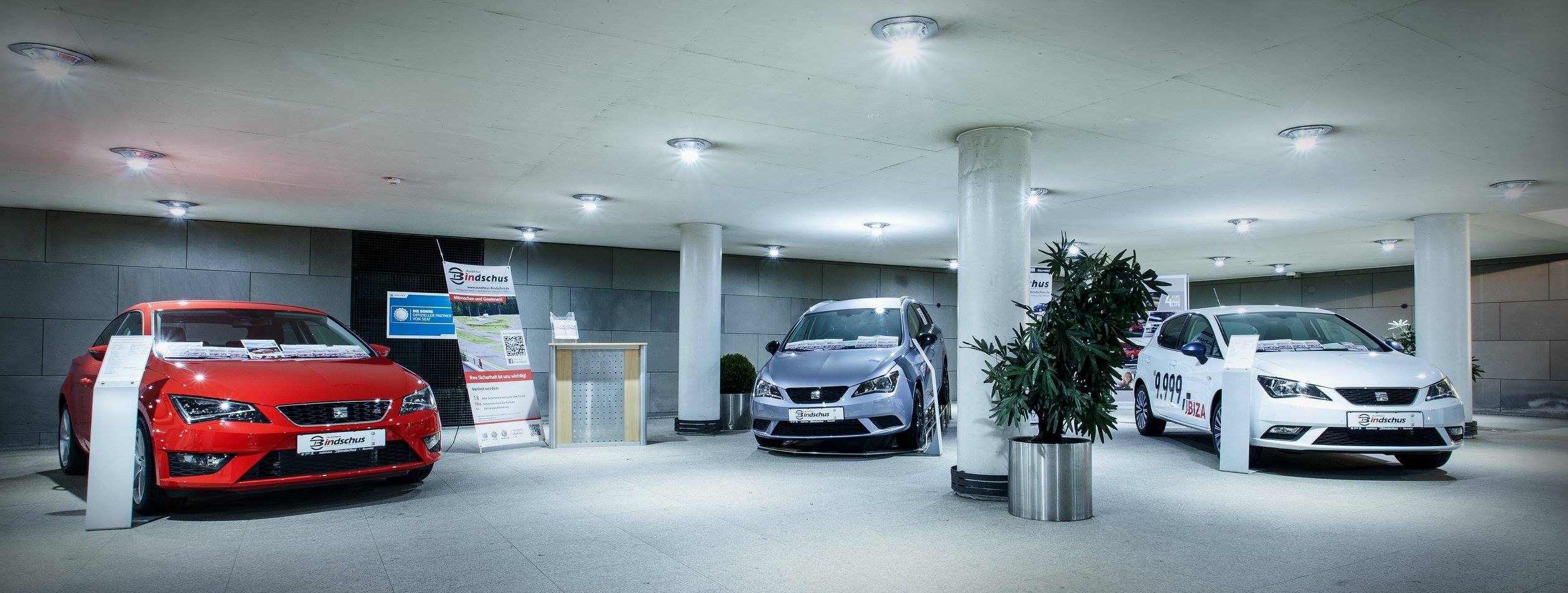 Ausstellungsraum eines Autohauses mit drei Fahrzeugen