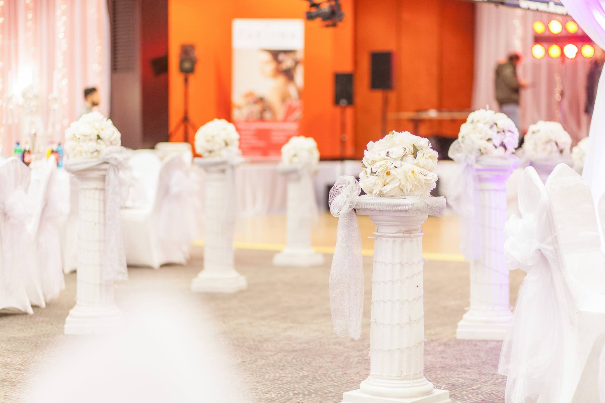 Festsaal mit weißen Säulen, Blumenschmuck und Stuhlhussen