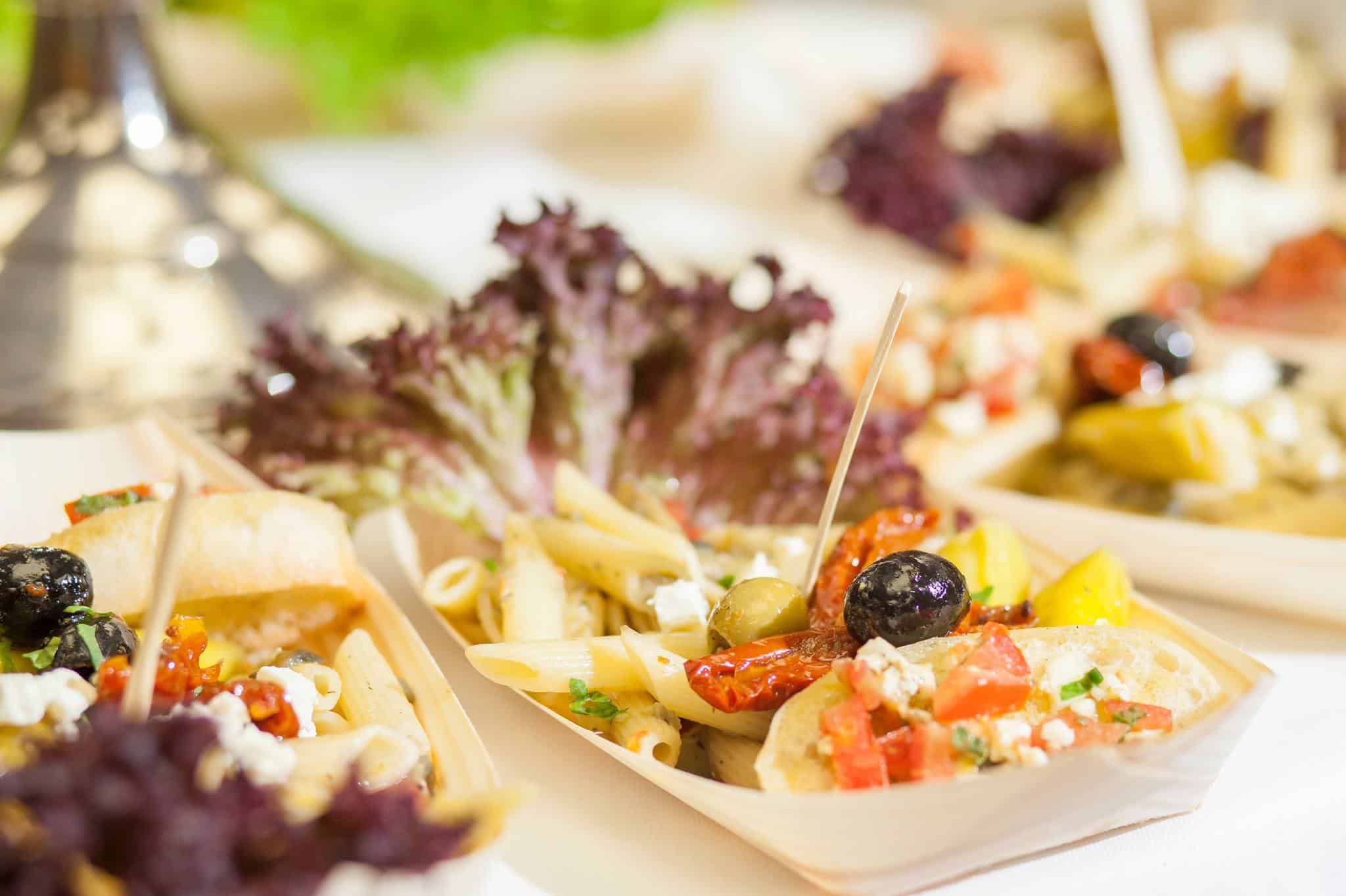 Fingerfood in Schälchen: Nudelsalat, Oliven und Salat auf einem Büfett