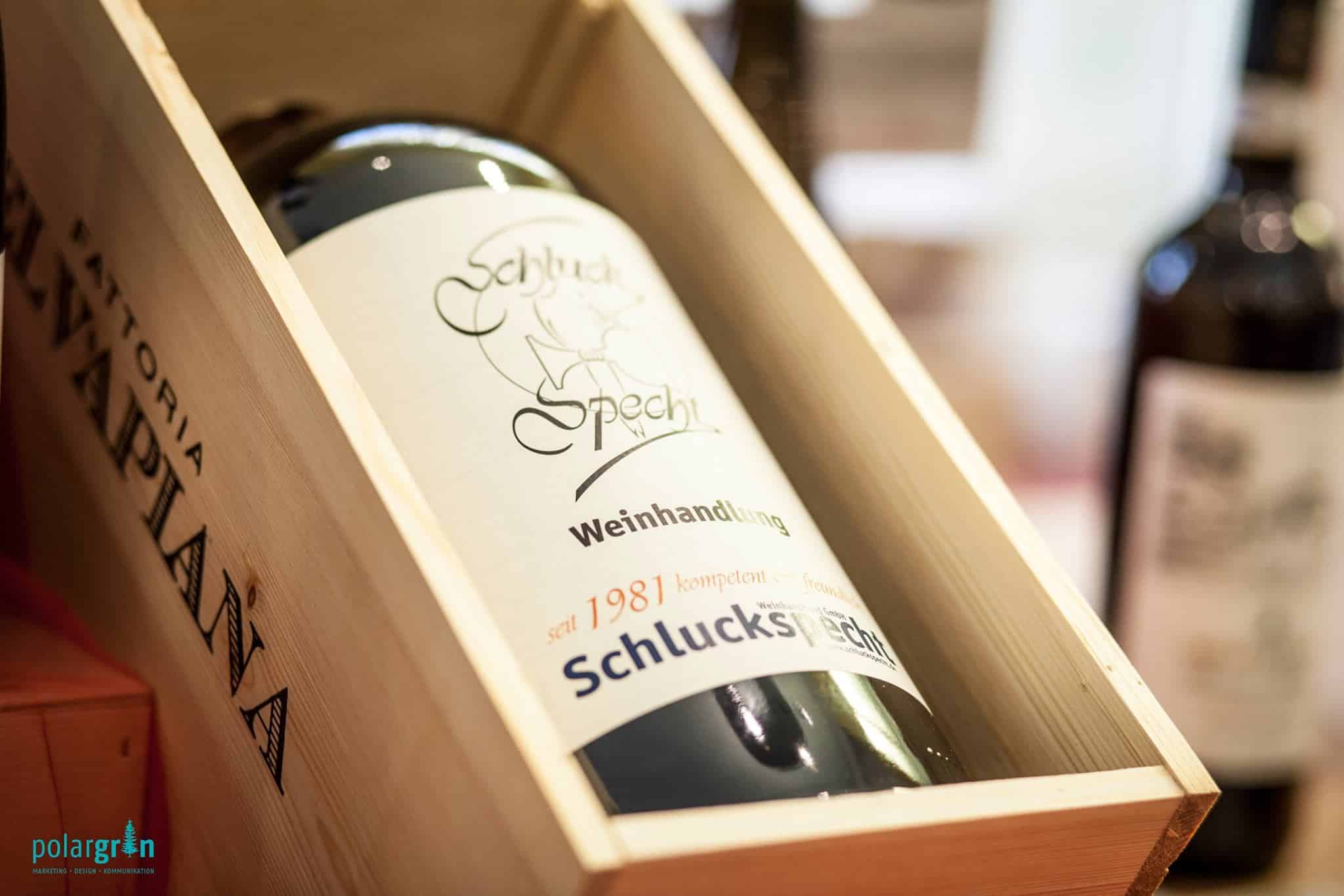 Weinflasche der Weinhandlung Schluckspecht in einer Holzkiste