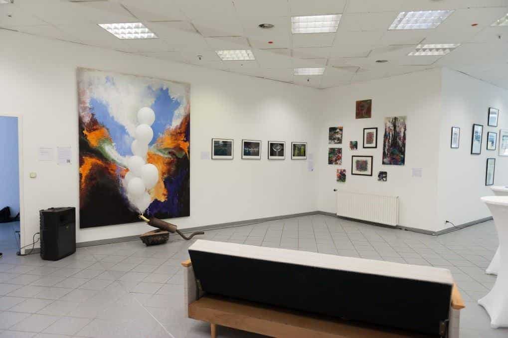Ausstellungsraum mit großem abstraktem Gemälde und Sitzbank