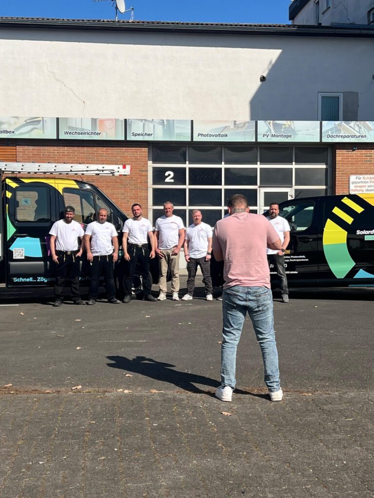 Fotograf nimmt das Team von Solardach Kassel vor der Firmenhalle auf